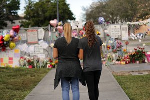 Sara Smith, left, and her daughter Karina Smith visit a makeshift memorial outside the Marjory Stoneman Douglas High School, where 17 students and faculty were killed in a mass shooting on Wednesday, in Parkland, Fla., Monday, Feb. 19, 2018.