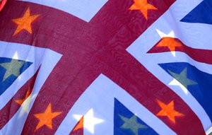 A British flag with stars of the EU flag seen through it flutters in the sunlight during an anti-Brexit demonstration opposite the House of Parliament in London, Tuesday, Nov. 27, 2018.