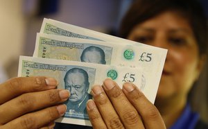 Amanda a member of staff at the Halifax bank holds the new British 5 pound sterling note that is made from polymer that is issued for the first time Tuesday, Sept., 13, 2016. The new note is expected to last some 5 years in circulation- whereas the old paper based note last only 2 years .(AP Photo/Alastair Grant)