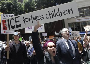 Protester Jessica Redford, bottom, holds up a sign while yelling outside of the Immigration and Customs Enforcement (ICE) office in San Francisco, Tuesday, June 19, 2018.