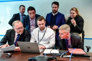 image for article:ABC's legal team and an IT specialist overlooking the AFP's search for emails and data. (ABC News: Brendan Esposito)