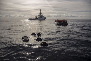 In this Friday, Dec. 21, 2018, photo, migrants sit in a rubber dinghy after Proactiva Open Arms, a Spanish NGO, spotted and rescued them in the Central Mediterranean Sea at 45 miles (72 kilometers) from Al Khums, Lybia.