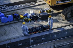 A body is carried away during the recovery operation at Margaret Bridge, the scene of the fatal boat accident in Budapest, Hungary, Tuesday, June 11, 2019.