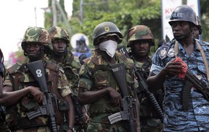 Soldiers stand guard after security forces broke up a protest over rumors of alleged vote counting irregularities, as voting continued for an unplanned second day in Accra, Ghana, Saturday, Dec. 8, 2012