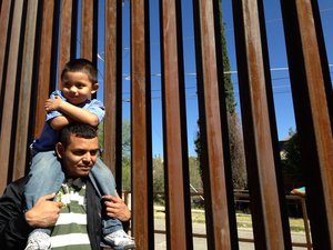 Three-year-old U.S. born Pablito rides on the shoulders of his Guatemalan father Ardani Rosales, near the Mexico-U.S. border wall in Nogales, in the Mexican state of Sonora, Wednesday, April 2, 2014, before presenting a request for humanitarian parole to return to the U.S.