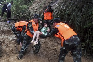 In this Saturday, June 8, 2019, photo released by Xinhua News Agency, rescuers transfer a girl from a floods hit Shanxi Village of Yongxin County in Ji'an City, east China's Jiangxi Province.