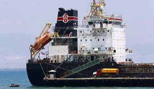 In this April 16, 2019 photo, a ship fills up on fuel from a tanker truck on the Thor terminal in Carrefour, a district of Port-au-Prince Haiti.