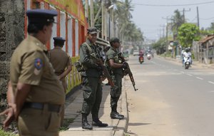 Sri Lankan army soldiers and police stand guard on a road in a Muslim neighborhood following overnight clashes in Poruthota, a village in Negombo, about 35 kilometers North of Colombo, Sri Lanka, Monday, May 6, 2019.