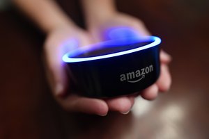 FILE - In this Aug. 16, 2018, file photo a child holds his Amazon Echo Dot in Kennesaw, Ga.