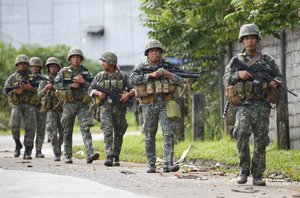 File - Philippine marines walk to the frontline in the continuing assaults to retake control of some areas of Marawi city Sunday, May 28, 2017 in southern Philippines.