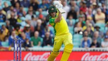 Aaron Finch, leaning forward onto his front foot, holds his straight bat at eye level. The ball has come off it.