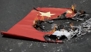 A mock Chinese national flag burns during a rally outside the Chinese Consulate in the financial district of Makati, metropolitan Manila to mark Independence Day on Wednesday, June 12, 2019.