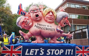 File - At the front of a demonstation against Brexit in Manchester a float showed a multi-headed chimera with the faces of Theresa May and three leading Brexit campaigners: Foreign Secretary Boris Johnson, Environment Secretary Michael Gove and Brexit Secretary David Davis, 1 October 2017