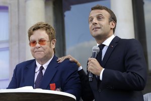 Emmanuel Macron, right, and Sir Elton John address the crowd in the courtyard of the presidential Elysee Palace