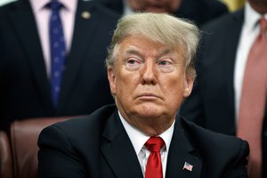 President Donald Trump listens during a signing ceremony for criminal justice reform legislation in the Oval Office of the White House, Friday, Dec. 21, 2018, in Washington