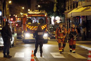 Firefighters and policemen stand on the scene of a fire in Paris, Tuesday, Feb. 5, 2019.