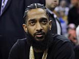 FILE - This March 29, 2018 file photo shows rapper Nipsey Hussle at an NBA basketball game between the Golden State Warriors and the Milwaukee Bucks in Oakland, Calif. Court documents show that Hussle and the man charged with killing him had a conversation about "snitching" shortly before Hussle was shot. (AP Photo/Marcio Jose Sanchez, File)