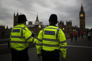 File - Police officers patrol Westminster Bridge with the Houses of Parliament in the background, on election day in London, Thursday, June 8, 2017.