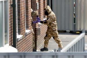 Emergency workers in military protective suits search the fenced off John Baker House for homeless people on Rollestone Street in Salisbury, England, Friday, July 6, 2018. British police are scouring sections of Salisbury and Amesbury in southwest England, searching for a container feared to be contaminated with traces of the deadly nerve agent Novichok. (AP Photo/Matt Dunham)