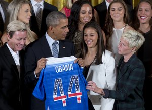 President Barack Obama holds a jersey he received from Head Coach Jill Ellis during a ceremony with the United States Women's National Soccer Team in the East Room of the White House in Washington Tuesday, Oct. 27, 2015, to honor them and their victory in the 2015 FIFA Women's World Cup.