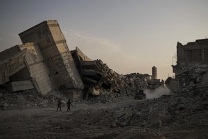 Iraqi soldiers walk in a damaged street as Iraqi forces continue their fight against Islamic State militants in parts of the Old City of Mosul, Iraq, Sunday, July 9, 2017.