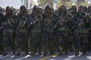 Wearing ghilli suits, Iranian army troops march in a military parade for the 35th anniversary of Iraq's 1980 invasion of Iran, in front of the shrine of late revolutionary founder Ayatollah Khomeini, just outside Tehran, Iran, Tuesday, Sept. 22, 2015.