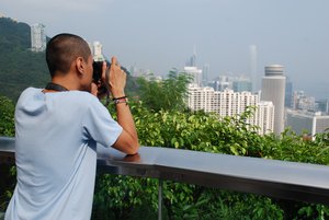 A tourist man taking photo of the city's great view using his SLR digital camera in Hong Kong , August 31, 2009.