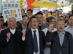 Occupy Central leaders, from right, Benny Tai, Chan Kin Man and Chu Yiu Ming shout slogans before entering a court in Hong Kong, Tuesday, April 9, 2019.