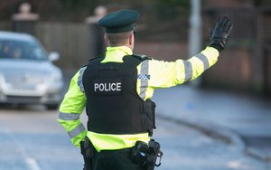 File - A police officer with the Police Service of Northern Ireland halts traffic.