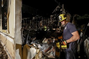 A fireman looks over a home Saturday, July 6, 2019 that burned after a earthquake in Ridgecrest, Calif.