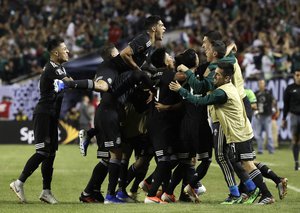 Mexico midfielder Jonathan Dos Santos (6) celebrates with teammates after scoring his first goal against United States during the second half of the CONCACAF Gold Cup final match at Soldier Field in Chicago, Sunday, July 7, 2019.