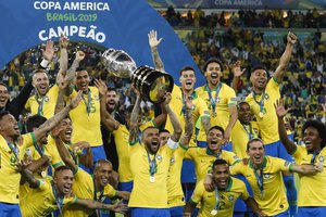 Brazil's Dani Alves lifts up his team's trophy after winning the final soccer match