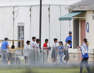 Immigrant children walk in a line outside the Homestead Temporary Shelter for Unaccompanied Children a former Job Corps site that now houses them, on Wednesday, June 20, 2018, in Homestead, Fla.