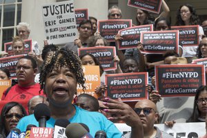 Gwen Carr, whose son Eric Garner was killed by an NYPD officer, is surrounded by supporters as she speak during a news conference outside City Hall, Tuesday, July 17, 2018, in New York.