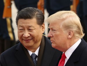 FILE - In this Nov. 9, 2017, file photo, U.S. President Donald Trump and Chinese President Xi Jinping participate in a welcome ceremony at the Great Hall of the People in Beijing, China.