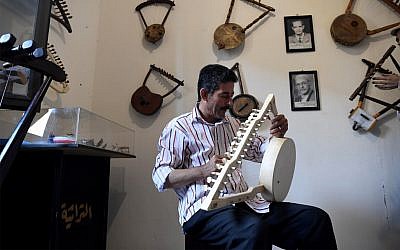 Egyptian craftsman Mohamed Ghaly adds the finishing touches on a semsemia that he made at the Canal 20 cultural museum in the northeastern city of Port Said at the northern terminus of the Suez Canal, on May 29, 2019. (Khaled Desouki/AFP)