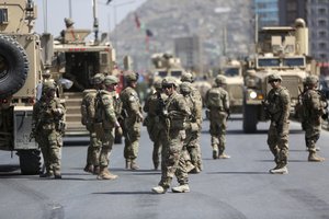 U.S. and Afghan security forces inspect the site of a suicide attack on NATO convoy in Kabul, Afghanistan, Sunday, Sept. 24, 2017.