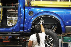 FILE- In this Sept. 27, 2018, file photo a United Auto Workers assemblyman works on a 2018 Ford F-150 truck being assembled at the Ford Rouge assembly plant in Dearborn, Mich.