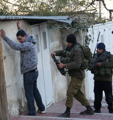 File - Israeli Golani soldiers searching a Palestinian in Tel Rumaida in the West Bank city of Hebron, by Gilbert checkpoint. Palestinians are routinely searched or detained.