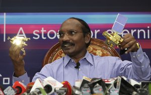 FILE- In this Aug. 20, 2019 file photo, Indian Space Research Organization (ISRO) Chairman Kailasavadivoo Sivan displays a model of Chandrayaan 2 orbiter and rover during a press conference at their headquarters in Bangalore, India.