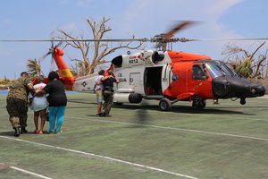 Members of the Coast Guard help victims of Hurricane Dorian to a Jayhawk helicopter for evacuation from the Bahamas, Sept. 4, 2019. The Coast Guard is providing humanitarian aid and supporting search and rescue efforts in the Bahamas following the hurricane.