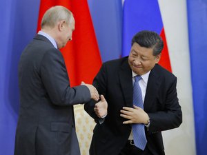 Chinese President Xi Jinping, right, and Russian President Vladimir Putin shake hands during the ceremony of presenting Xi Jinping degree from St. Petersburg State University at the St. Petersburg International Economic Forum in St. Petersburg, Russia, Thursday, June 6, 2019.