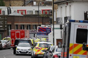 The train, on which a homemade bomb exploded, stands above parked police vehicles on a road below at Parsons Green subway station in London, Friday, Sept. 15, 2017.