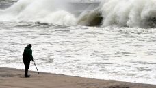 A man uses a medal detector as powerful