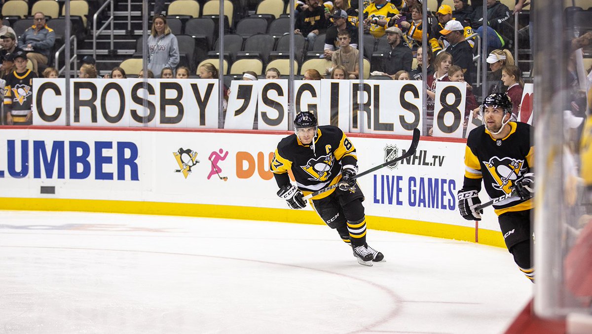 Crosby skates by young girls with "Crosby's Girls 87" signs.