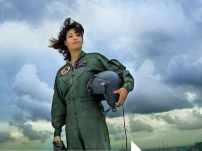 Marisol Chalas wearing her flight uniform and holding a helmet standing against a cloud-filled sky.