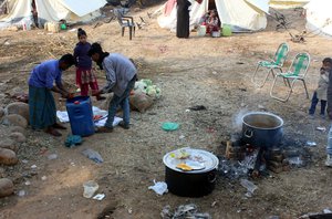 Myanmar Muslim refugees cook food after a fire in a slum area on the outskirts of Jammu, India, Saturday, Nov. 28, 2016