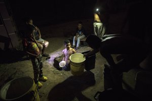 A youth standing inside a well draws water from the roadside in Cabimas, Venezuela, July 12, 2019.