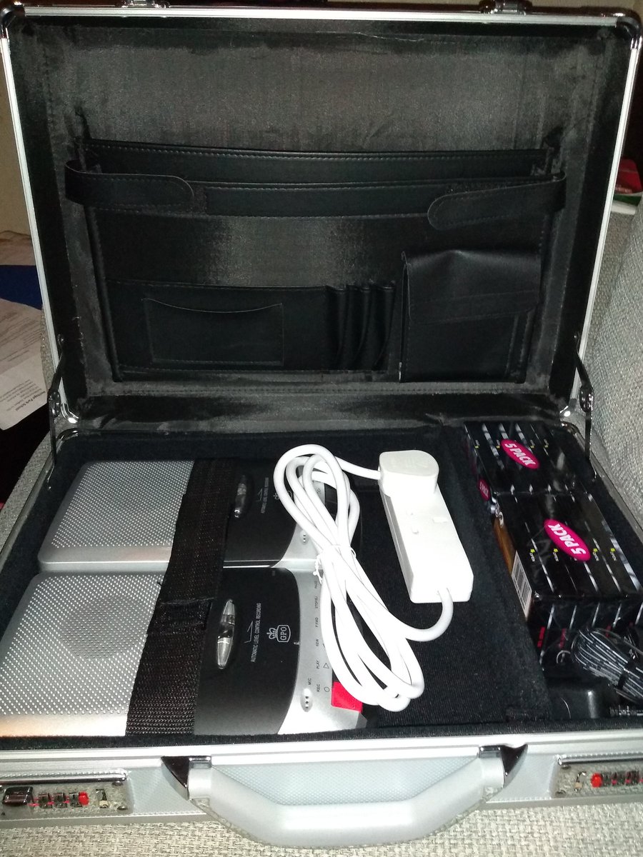 An image of an open attaché case containing two flatbed cassette recorders, an extension lead and sealed cassette tapes.