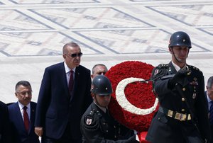 In this file photo dated Thursday, Aug. 1, 2019, Turkey's President Recep Tayyip Erdogan, center left, with ministers and army commanders as they follow a guard of honor at the mausoleum of Turkey's founder Mustafa Kemal Ataturk, in Ankara, Turkey.